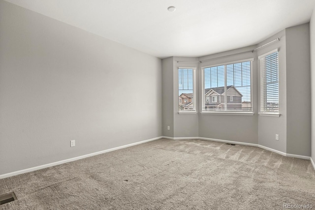 carpeted empty room with visible vents and baseboards