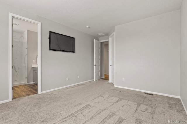 unfurnished room with carpet flooring, visible vents, and baseboards