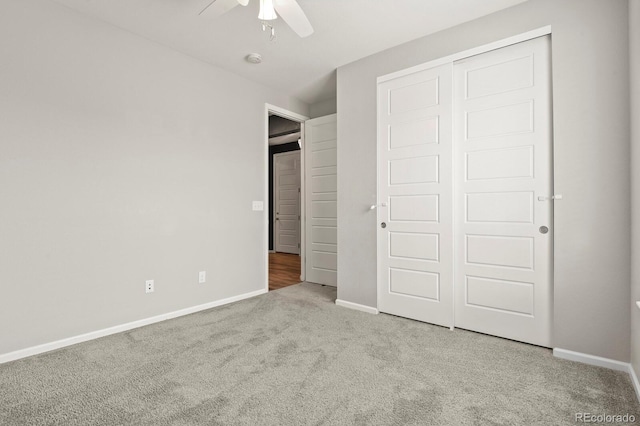 unfurnished bedroom featuring a ceiling fan, carpet, a closet, and baseboards