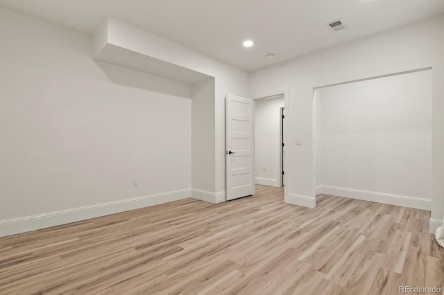 spare room featuring light wood-style floors, baseboards, visible vents, and recessed lighting