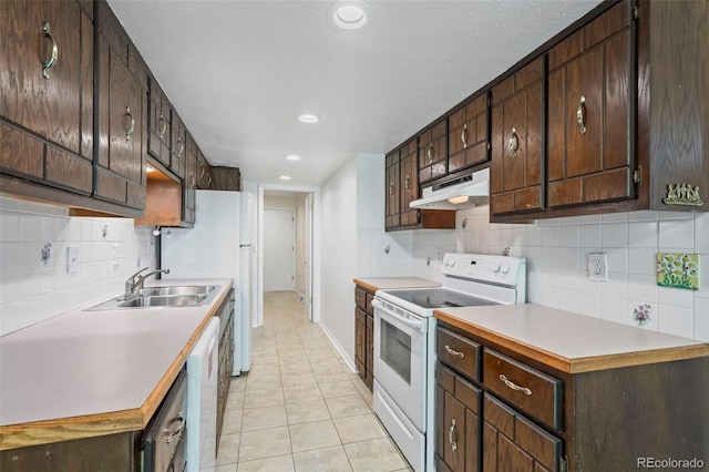3631 W 79th Ave Unit A2, Westminster, CO 80030 - kitchen with white appliances, under cabinet range hood, dark brown cabinets, decorative backsplash, and recessed lighting