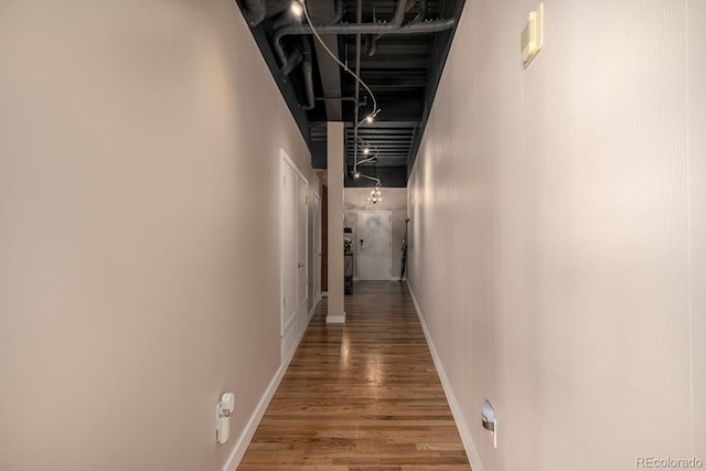 hallway featuring baseboards and wood finished floors