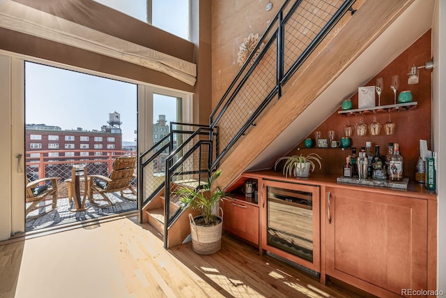 bar with a view of city, wine cooler, plenty of natural light, and wet bar