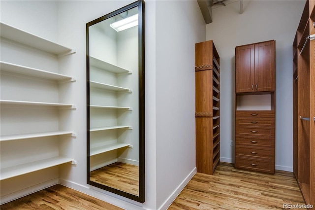 walk in closet with light wood-style flooring