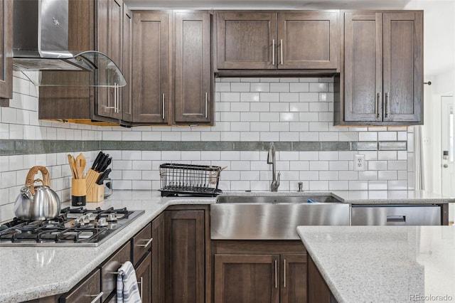 kitchen featuring light stone counters, sink, backsplash, and stainless steel appliances