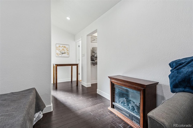 hallway featuring dark hardwood / wood-style floors and lofted ceiling