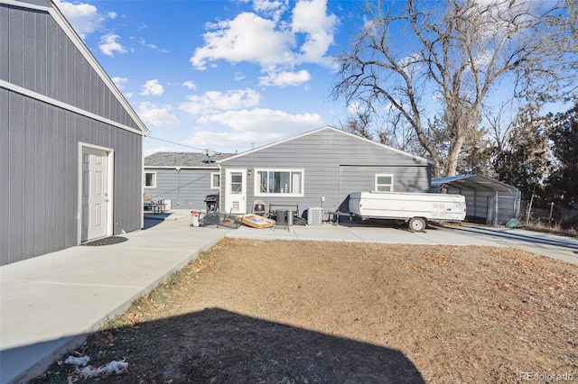 rear view of property featuring central air condition unit and a carport