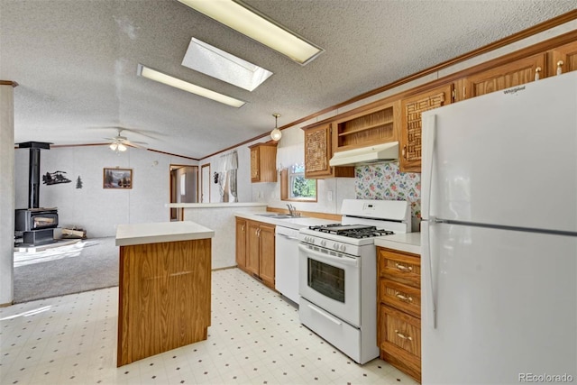 1360 Kiowa Rd, Florissant, CO 80816 - kitchen featuring white appliances, a sink, under cabinet range hood, a wood stove, and light floors