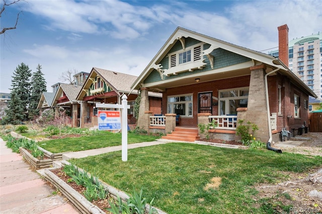 260 N Grant St, Denver, CO 80203 - craftsman inspired home featuring brick siding, a front lawn, covered porch, and a chimney