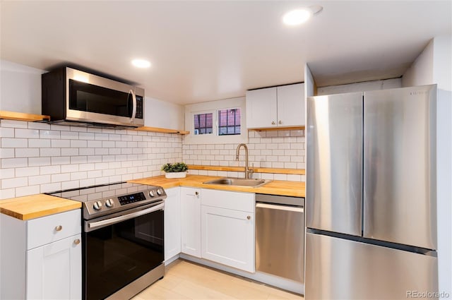 260 N Grant St, Denver, CO 80203 - kitchen featuring wood counters, stainless steel appliances, open shelves, a sink, and white cabinetry