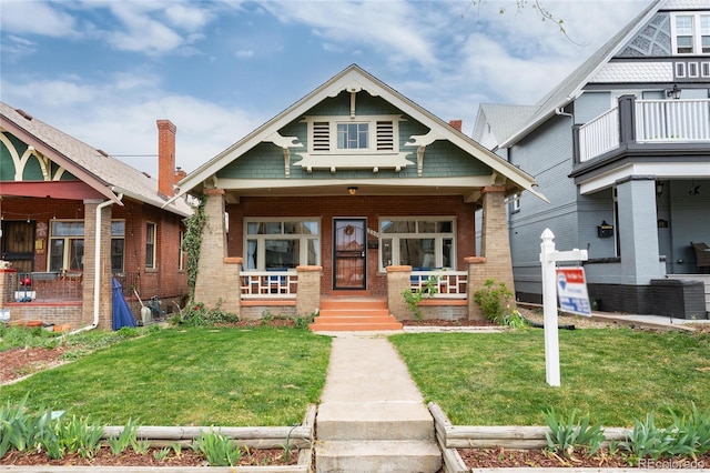 260 N Grant St, Denver, CO 80203 - view of front facade featuring covered porch, a front lawn, and brick siding