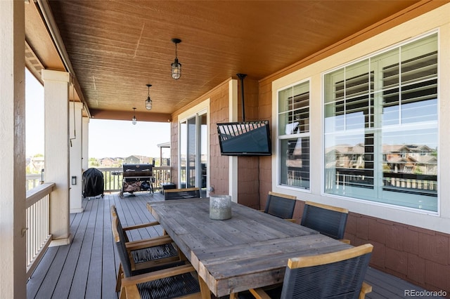 deck with outdoor dining space and covered porch