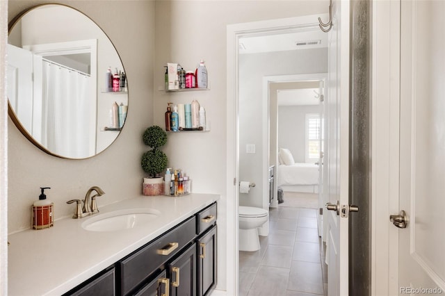 full bath featuring tile patterned floors, toilet, vanity, and ensuite bath