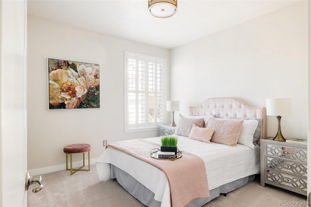 bedroom featuring light carpet and baseboards