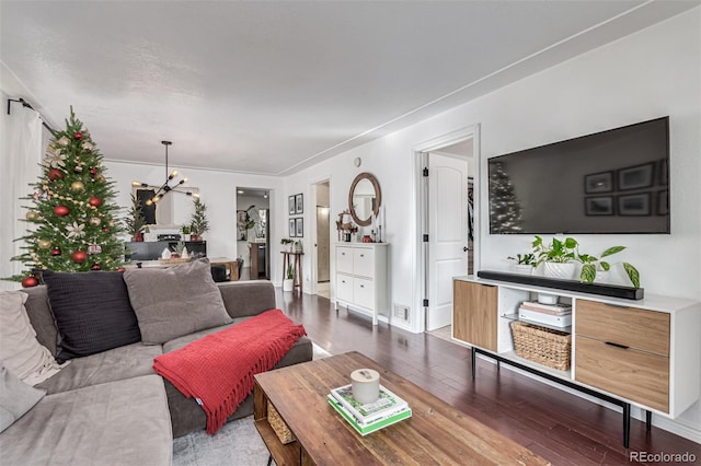 living room featuring wood-type flooring and a notable chandelier