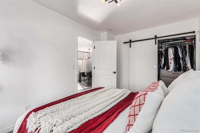 bedroom with a barn door and a closet