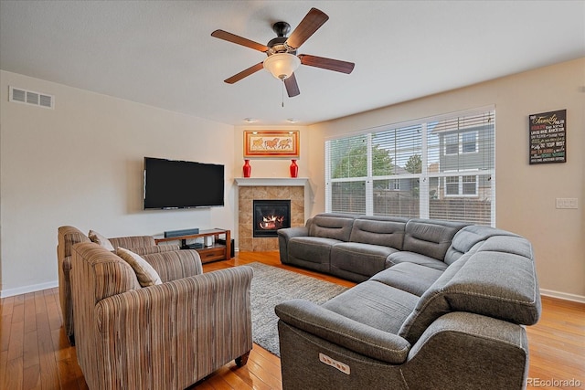 6461 S Ider St, Aurora, CO 80016 - living room featuring a ceiling fan, light wood-style floors, baseboards, and a tiled fireplace