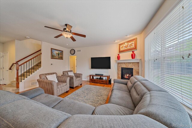 6461 S Ider St, Aurora, CO 80016 - living area with light wood-type flooring, stairs, a ceiling fan, a fireplace, and baseboards