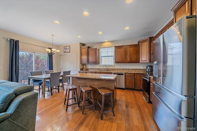 6461 S Ider St, Aurora, CO 80016 - kitchen featuring stainless steel appliances, a sink, a chandelier, open floor plan, and plenty of natural light