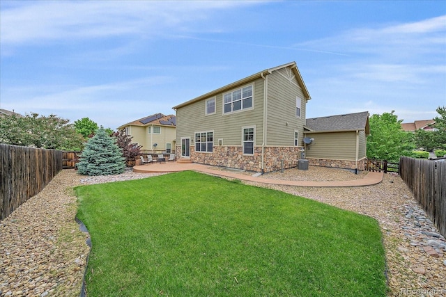 6461 S Ider St, Aurora, CO 80016 - back of property with stone siding, a patio, and cooling unit