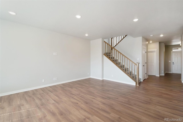954 Plum Creek Ct, Brighton, CO 80601 - unfurnished living room featuring stairs, recessed lighting, and wood finished floors