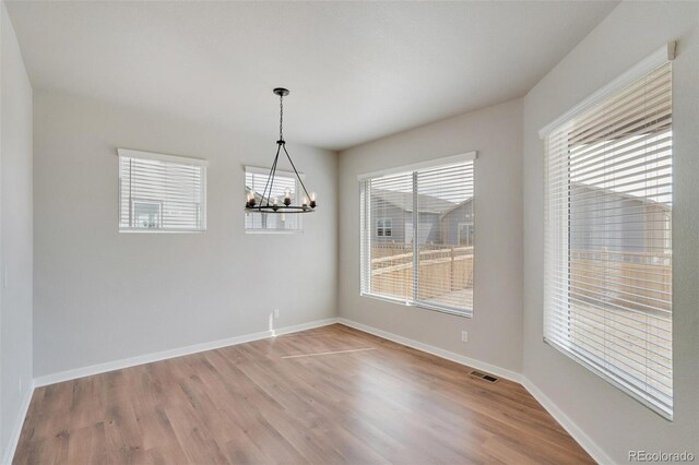 954 Plum Creek Ct, Brighton, CO 80601 - unfurnished dining area with a chandelier and wood finished floors