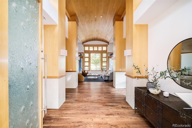 hall with vaulted ceiling, wood ceiling, and wood finished floors