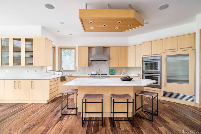 1070 Cypress Way, Castle Rock, CO 80108 - kitchen with wall chimney range hood, stainless steel double oven, light countertops, light brown cabinets, and recessed lighting