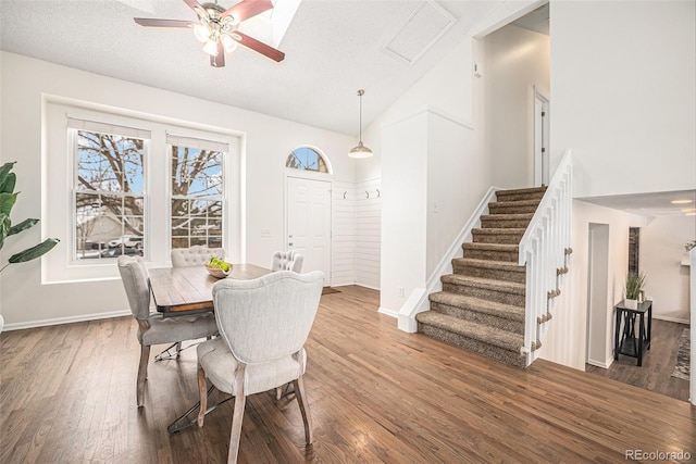 dining area featuring hardwood / wood-style flooring, ceiling fan, high vaulted ceiling, and a textured ceiling