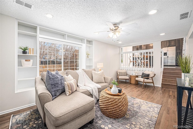 living room with hardwood / wood-style floors, plenty of natural light, and a textured ceiling