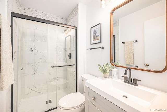 bathroom with an enclosed shower, vanity, and toilet