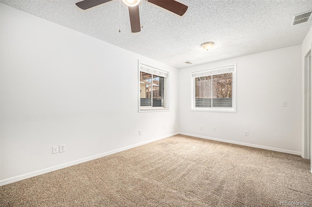 spare room with a textured ceiling and carpet flooring