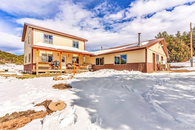 snow covered property with a porch