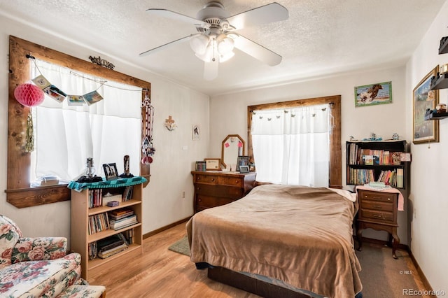 68600 State Highway 69, Westcliffe, CO 81252 - bedroom featuring multiple windows, wood finished floors, a textured ceiling, and a ceiling fan