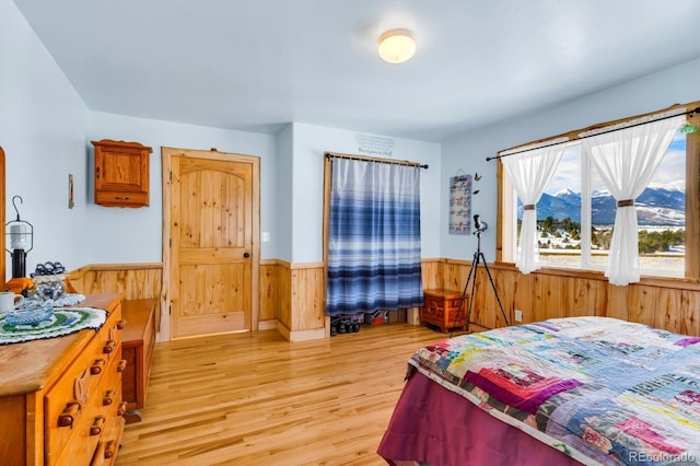 bedroom featuring light hardwood / wood-style flooring and wood walls