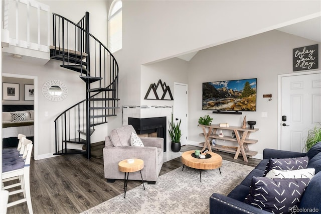 8311 S Upham Way Unit 1-207, Littleton, CO 80128 - living room featuring high vaulted ceiling, wood finished floors, stairway, and a tile fireplace
