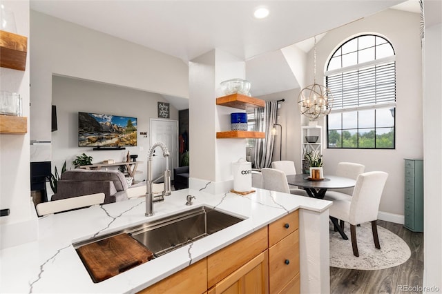 8311 S Upham Way Unit 1-207, Littleton, CO 80128 - kitchen with light stone counters, wood finished floors, a chandelier, open shelves, and open floor plan