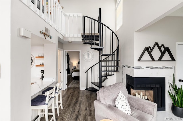 8311 S Upham Way Unit 1-207, Littleton, CO 80128 - living room with a towering ceiling, stairway, dark wood finished floors, and a multi sided fireplace