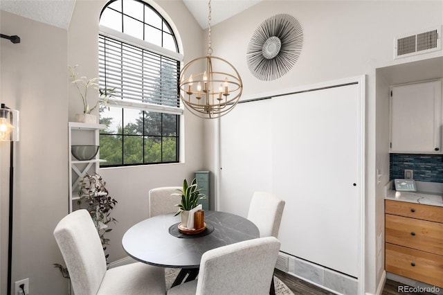 8311 S Upham Way Unit 1-207, Littleton, CO 80128 - dining area featuring vaulted ceiling, a chandelier, and wood finished floors