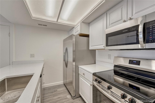 4283 S Salida Way Unit 8, Aurora, CO 80013 - kitchen featuring stainless steel appliances, light wood-style flooring, white cabinets, and light countertops
