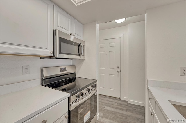 4283 S Salida Way Unit 8, Aurora, CO 80013 - kitchen with appliances with stainless steel finishes, white cabinets, light wood finished floors, and light countertops