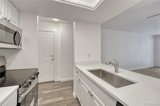 4283 S Salida Way Unit 8, Aurora, CO 80013 - kitchen featuring appliances with stainless steel finishes, light wood-style flooring, and white cabinetry