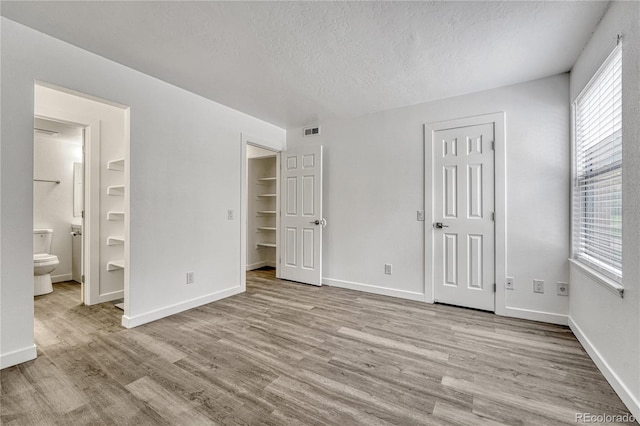 4283 S Salida Way Unit 8, Aurora, CO 80013 - unfurnished bedroom with wood finished floors, a textured ceiling, and ensuite bath