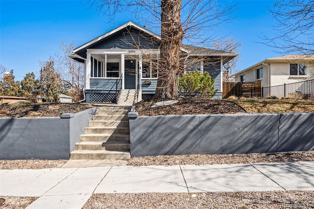 bungalow-style house with a porch, stairway, and fence