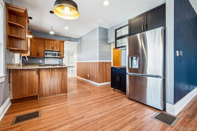 kitchen featuring visible vents, wainscoting, light wood-style flooring, stainless steel appliances, and open shelves