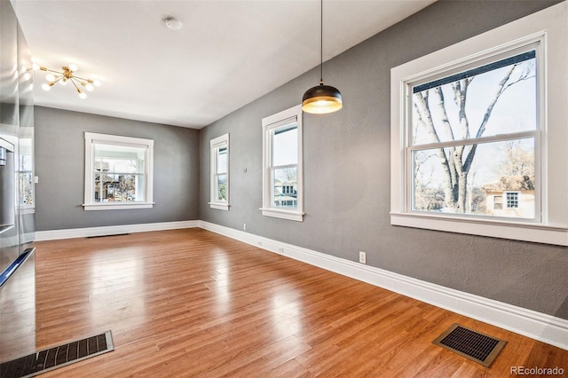 interior space featuring visible vents, baseboards, and wood finished floors