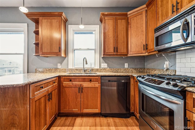 kitchen featuring brown cabinets, appliances with stainless steel finishes, open shelves, and a sink