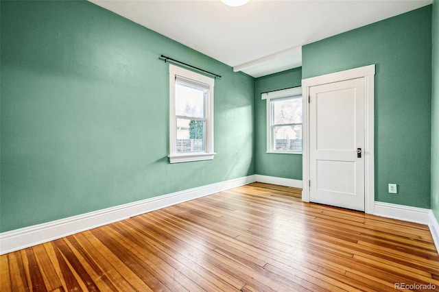 empty room featuring light wood finished floors and baseboards