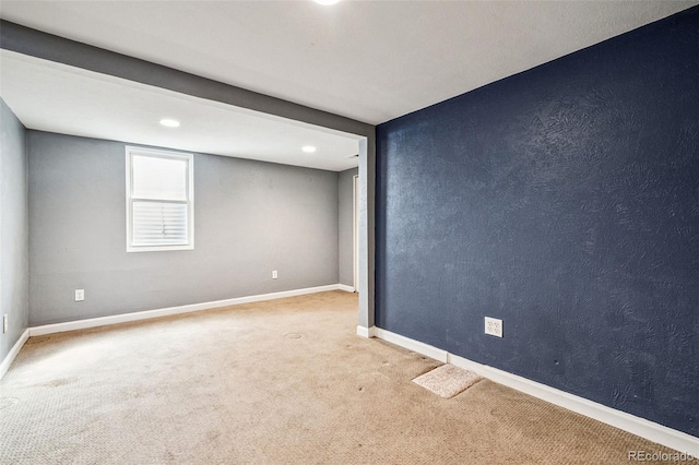 empty room featuring carpet flooring, a textured wall, and baseboards