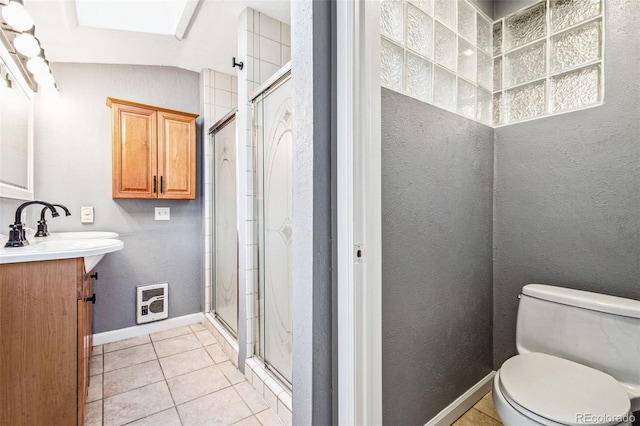 bathroom with vanity, baseboards, a shower stall, tile patterned floors, and toilet